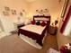 Cozy bedroom featuring a queen bed with burgundy accents and decorative elements at 7619 Teal Trace, Bradenton, FL 34203