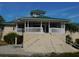 Exterior view of the clubhouse, featuring a green roof, columns, and wide stairs at 7619 Teal Trace, Bradenton, FL 34203