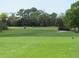 View of the green golf course with players and golf carts at 7619 Teal Trace, Bradenton, FL 34203