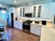 Well-lit kitchen featuring white cabinets, stainless steel appliances, and modern backsplash at 7619 Teal Trace, Bradenton, FL 34203