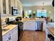 Open kitchen with stainless steel dishwasher, gas range, and views to the dining area at 7619 Teal Trace, Bradenton, FL 34203