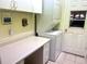 Functional laundry room with a stacked washer and dryer, counter space, and storage cabinets at 7619 Teal Trace, Bradenton, FL 34203