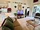 Inviting living room with a comfortable sofa, entertainment center, and view of the open-concept kitchen at 7619 Teal Trace, Bradenton, FL 34203