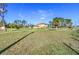 Expansive grassy backyard with a view of the home in the distance, under a bright blue sky at 8059 Strasse Blvd, Punta Gorda, FL 33982