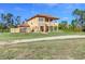 Two-story home with a tile roof, a front porch, and a spacious yard with gravel driveway at 8059 Strasse Blvd, Punta Gorda, FL 33982