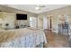 Bedroom featuring ceiling fan, tiled floors, a TV, and view to an attached bathroom at 8059 Strasse Blvd, Punta Gorda, FL 33982