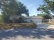 Cozy single-Gathering home with mature landscaping, front lawn, and driveway leading to the garage at 2040 Pine Ridge Dr, Clearwater, FL 33763