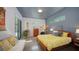 Stylish bedroom featuring a yellow patterned bedspread, concrete floors, and sliding glass doors to the backyard at 2434 Wood St, Sarasota, FL 34237