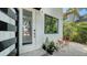Close-up of front door with textured glass, black horizontal bars, and plants around the walkway to the entrance at 2434 Wood St, Sarasota, FL 34237