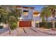 Modern two-story home featuring a wooden garage door, sleek design, well-kept yard and a private entrance gate at 2434 Wood St, Sarasota, FL 34237