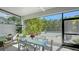 Screened lanai features outdoor seating, view of tropical plants, and a tranquil pool area at 2434 Wood St, Sarasota, FL 34237