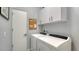 Well-lit laundry room with white cabinets and modern washer and dryer units at 2434 Wood St, Sarasota, FL 34237