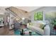 Stylish living room with a modern staircase, sleek concrete floors, large windows, stylish furniture, and recessed lighting at 2434 Wood St, Sarasota, FL 34237