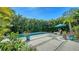 Backyard oasis with a refreshing swimming pool, landscaped with lush tropical plants, and a relaxing lounge area at 2434 Wood St, Sarasota, FL 34237