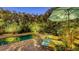 Relaxing backyard pool area with tropical landscaping, comfortable loungers, and a shaded umbrella at 2434 Wood St, Sarasota, FL 34237