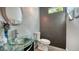 Stylish powder room with glass bowl sink, tiled wall, round mirror, and modern fixtures at 2434 Wood St, Sarasota, FL 34237