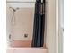Close up of a pink bathtub with black curtain and white tiled walls at 2762 W Vina Del Mar Blvd, St Pete Beach, FL 33706