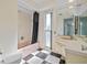 Bathroom featuring checkered floors, pink bathtub and vanity at 2762 W Vina Del Mar Blvd, St Pete Beach, FL 33706