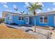 Inviting front entrance of a blue home with a well-maintained landscape and charming architectural details at 2762 W Vina Del Mar Blvd, St Pete Beach, FL 33706