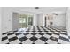 Spacious living room with striking black and white checkered floors and sliders to the backyard at 2762 W Vina Del Mar Blvd, St Pete Beach, FL 33706