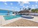 Clear blue swimming pool and hot tub with a tiki hut and outdoor space at 2762 W Vina Del Mar Blvd, St Pete Beach, FL 33706
