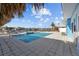 A sparkling pool with a nearby water view under a bright blue sunny sky at 2762 W Vina Del Mar Blvd, St Pete Beach, FL 33706