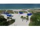 Aerial view of blue beach pavilions surrounded by sandy dunes, palm trees and coastal greenery at 3060 Grand Bay Blvd # 154, Longboat Key, FL 34228