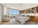 Bright bedroom with built-in shelving, water view, and access to the balcony at 3060 Grand Bay Blvd # 154, Longboat Key, FL 34228