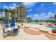 Beautiful pool area with tropical landscaping, lounge seating, and building in background at 3060 Grand Bay Blvd # 154, Longboat Key, FL 34228