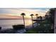 Scenic beach view featuring palm trees, calm waters, and a vibrant sunset, perfect for coastal living at 3460 Wild Oak Bay Blvd # 145, Bradenton, FL 34210