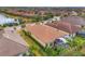 An aerial view of a home with a tile roof, screened-in lanai, and a manicured lawn at 5116 Tivoli Run, Bradenton, FL 34211