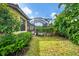 A backyard with lush greenery leading to a screened-in pool enclosure with ample privacy at 5116 Tivoli Run, Bradenton, FL 34211