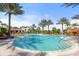 A large community pool with palm trees and lounge chairs, with a view of the poolside bar at 5116 Tivoli Run, Bradenton, FL 34211
