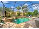 Screened-in pool and spa area featuring waterfall features and lush landscaping for a private oasis at 5116 Tivoli Run, Bradenton, FL 34211