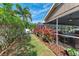 Manicured backyard with a screened-in patio, lush greenery, and a white fence at 5708 39Th Street E Cir, Bradenton, FL 34203