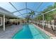 Screened-in pool area features a large, sparkling pool, brick paver deck and outdoor seating with lush tropical landscaping at 5708 39Th Street E Cir, Bradenton, FL 34203