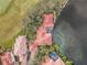 Aerial view of a lakeside house with pool and red tile roof in a tropical neighborhood at 7460 Monte Verde, Sarasota, FL 34238