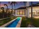 A serene backyard featuring a narrow water feature and lush landscaping, adjacent to the modern-style home at 8501 Midnight Pass Rd, Sarasota, FL 34242