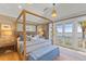 Cozy bedroom featuring a four-poster bed, water views, and natural textures for a serene retreat at 8501 Midnight Pass Rd, Sarasota, FL 34242