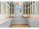 Butler's pantry with custom cabinets, counter space, and accent lighting at 8501 Midnight Pass Rd, Sarasota, FL 34242