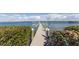 A private wooden dock extending into the tranquil water, surrounded by lush greenery and natural beauty at 8501 Midnight Pass Rd, Sarasota, FL 34242