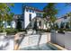 Elegant white home showcasing a gorgeous water feature and lush landscaping at 8501 Midnight Pass Rd, Sarasota, FL 34242