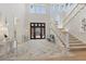 Bright foyer featuring a grand staircase, soaring ceilings, and elegant tile flooring at 8501 Midnight Pass Rd, Sarasota, FL 34242