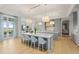A bright, open kitchen features double islands, modern lighting, and stylish seating with views to the water at 8501 Midnight Pass Rd, Sarasota, FL 34242