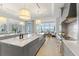 A large kitchen with marble counters and high-end appliances features water views and an inviting living space at 8501 Midnight Pass Rd, Sarasota, FL 34242