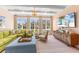 Bright living room with light green sofa, rattan chair, TV, and built in storage at 8501 Midnight Pass Rd, Sarasota, FL 34242