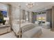 Luxurious main bedroom with a canopy bed, elegant chandelier, and views of a stunning sunset at 8501 Midnight Pass Rd, Sarasota, FL 34242