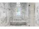 Elegant walk-in shower featuring marble walls, a rainfall shower head, and a built-in bench at 8501 Midnight Pass Rd, Sarasota, FL 34242
