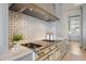A chef's kitchen boasts a high-end range and tile backsplash, complemented by custom cabinetry and finishes at 8501 Midnight Pass Rd, Sarasota, FL 34242
