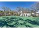 Well-maintained tennis court with a view of the charming pool house and beautiful landscaping at 8501 Midnight Pass Rd, Sarasota, FL 34242